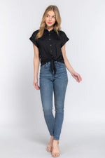 Chic women's stretch top in black, featuring a front tie detail and short sleeves, showcased by a smiling young woman in high-waisted jeans from the Cecelia store.