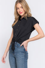 Elegant short-sleeved black stretch top, featuring a stylish front tie detail, showcased on a smiling blonde model against a plain white background.