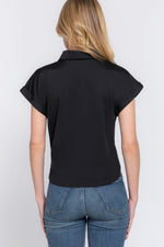 Black stretch top with front tie detail for a stylish casual look, worn by a young woman with long blonde hair against a plain background.