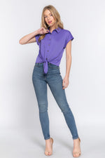 Stylish purple short sleeve stretch top with a front tie, worn by a smiling young woman on a white background.