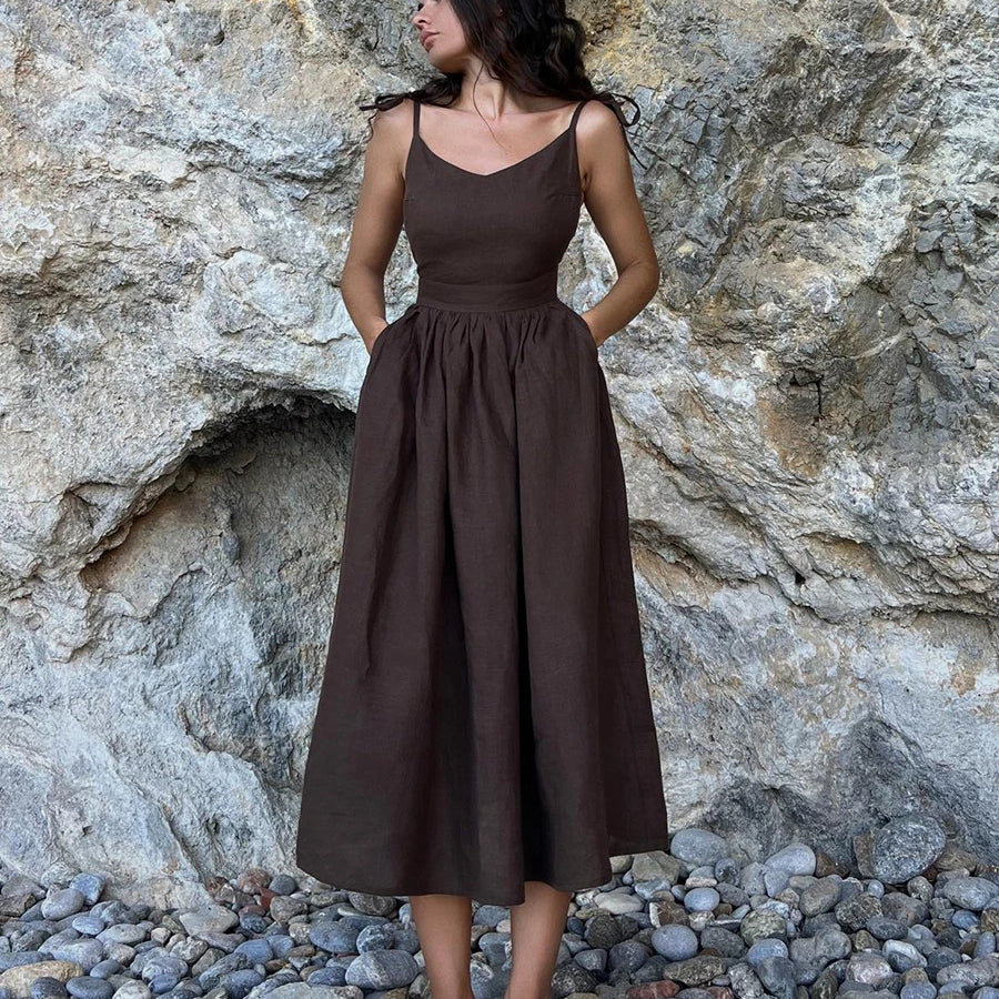 Elegant beach-style vintage loose A-line sling long dress from Cecelia, standing against a rocky backdrop.